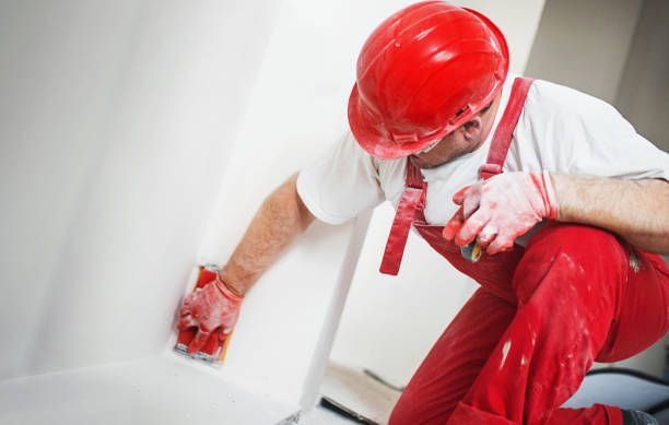 A professional contractor applying joint compound for a seamless drywall finish.