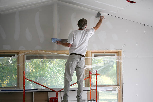 A technician performing timely drywall repair to fix wall damage.